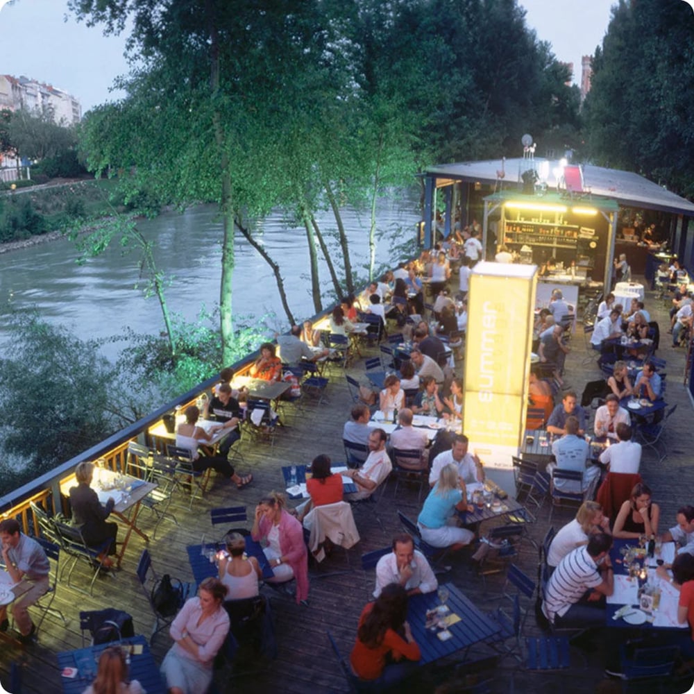 Belebte Restaurant-Terrasse am Flussufer