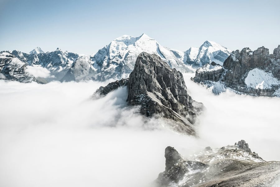 Schroffe Berggipfel ragen aus einem Wolkenmeer